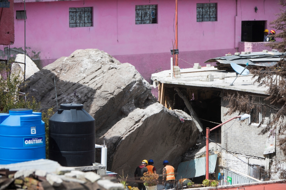 Rescue workers inspect an area damaged by a landslide, caused by heavy rains and an earthquake that loosened the hillside, at the Cerro del Chiquihuite, in the municipality of Tlalnepantla de Baz, Mexico September 12, 2021.REUTERS/Luis Cortes