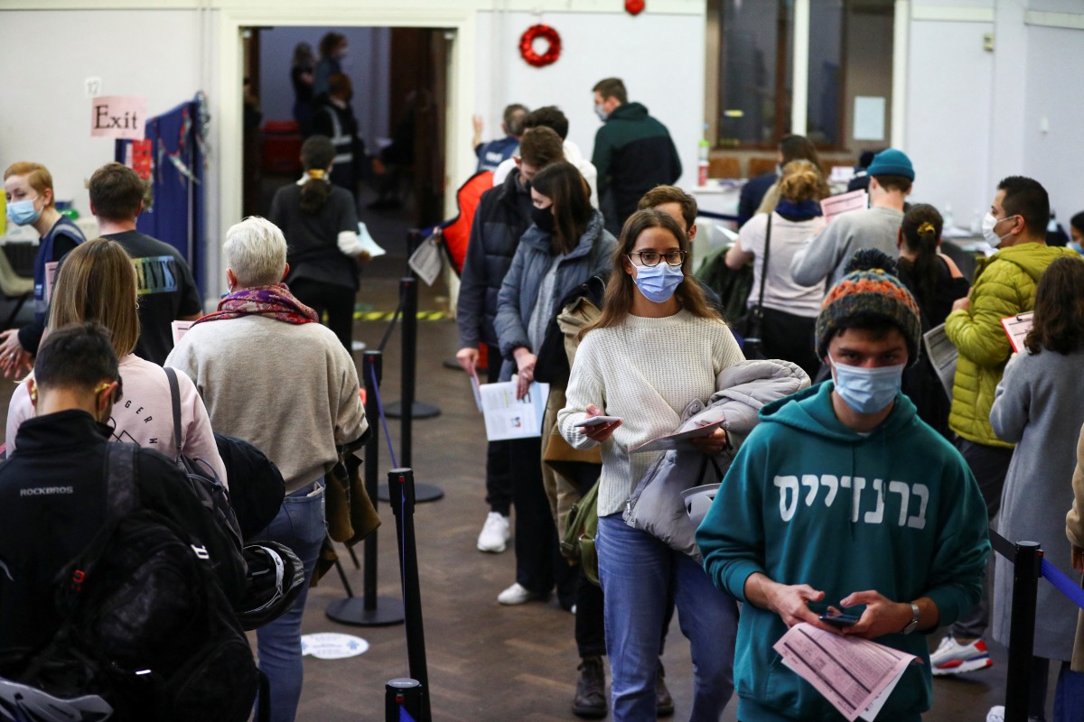 People queue at a coronavirus disease (COVID-19) vaccination centre in London, Britain, December 15, 2021. REUTERS/Hannah McKay
