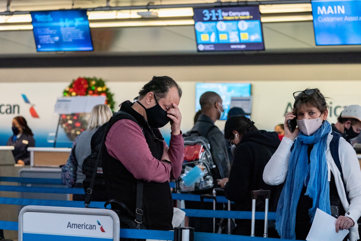 Passengers line up at John F. Kennedy International Airport during the spread of the Omicron coronavirus variant in Queens, New York City, U.S., December 26, 2021. REUTERS/Jeenah Moon
