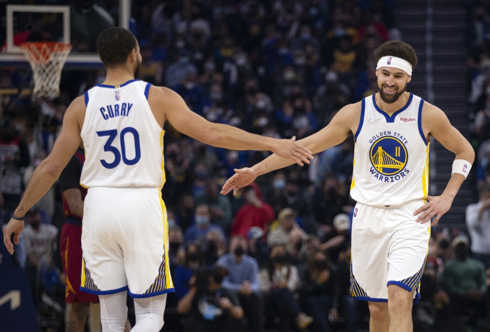 Golden State Warriors guard Klay Thompson (11) gets a congratulatory handshake from teammate Stephen Curry (30) after making a basket against the Cleveland Cavaliers during the first quarter at Chase Center. Mandatory Credit: D. Ross Cameron
