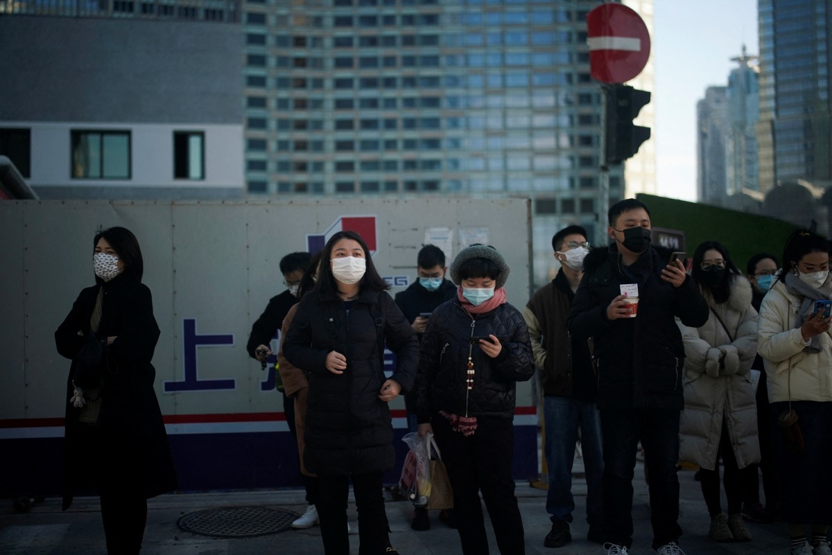 People wearing protective masks walk on a street, following new cases of the coronavirus disease (COVID-19), in SHANGHAI, China January 14, 2022. REUTERS/Aly Song
