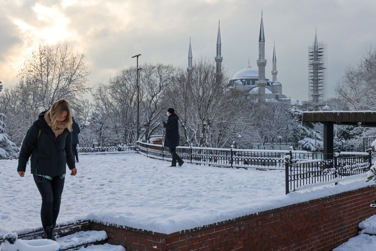 Tourists walk along Sultanahmet Square as Sultan Ahmet mosque, popularly known as the Blue Mosque, is seen in the background during a snowy day in Istanbul, Turkey, January 24, 2022. REUTERS/Umit Bektas
