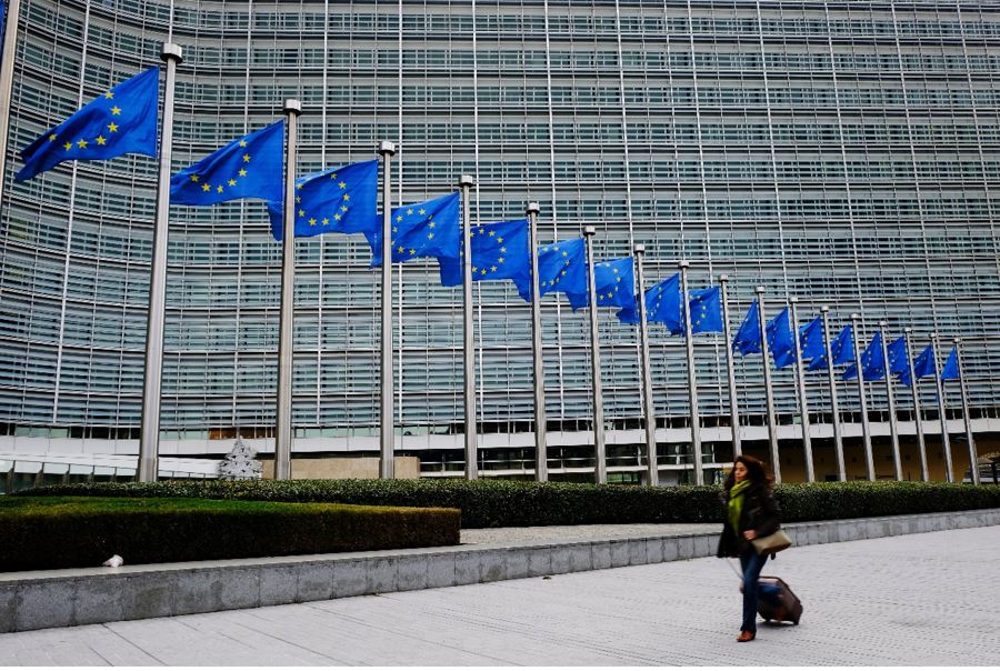 A woman walks outside of the European Commission's Berlaymont building in Brussels, Belgium