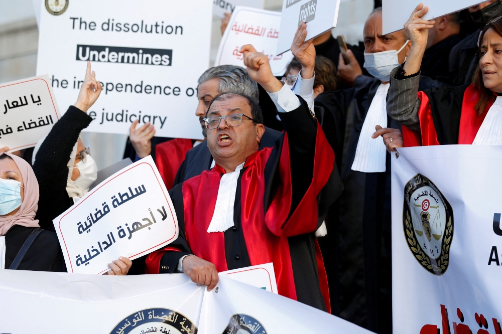 Tunisian judges display signs and banners during a protest against President Kais Saied's move to dissolve the Supreme Judicial Council, in Tunis, Tunisia, February 10, 2022. REUTERS.