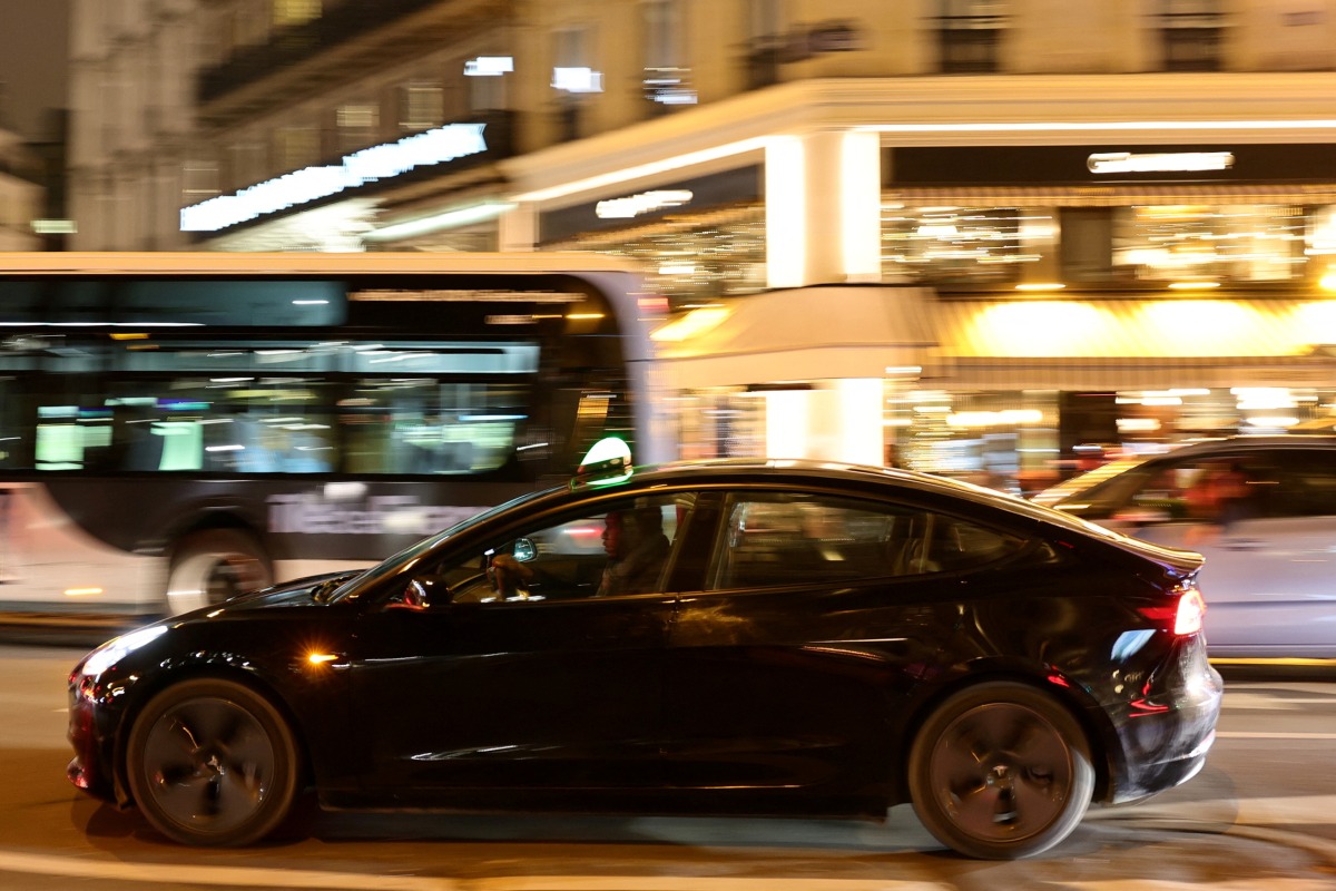 FILE PHOTO: A man drives a Tesla taxi car in Paris, France, December 14, 2021. REUTERS/Sarah Meyssonnier/File Photo
