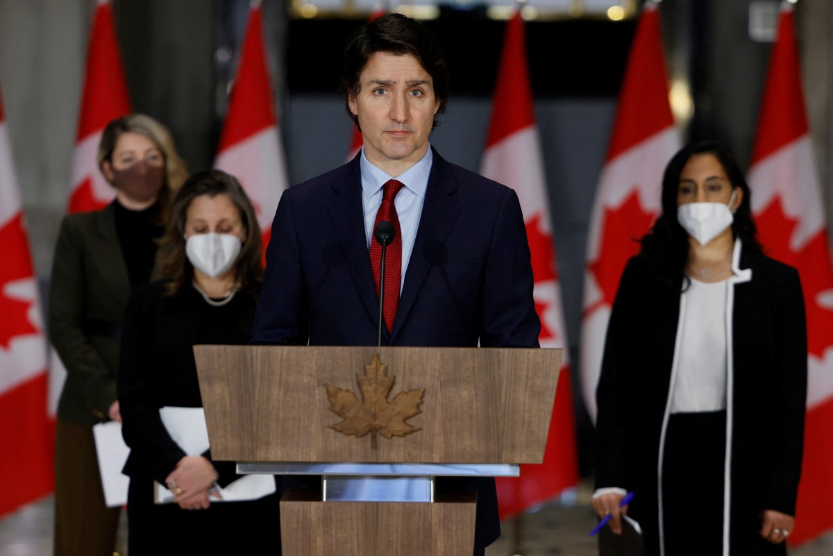 Canada's Prime Minister Justin Trudeau, with Minister of Foreign Affairs Melanie Joly, Deputy Prime Minister and Minister of Finance Chrystia Freeland, and Minister of National Defence Anita Anand, attends a news conference in Ottawa, Ontario, Canada February 24, 2022. REUTERS/Blair Gable
