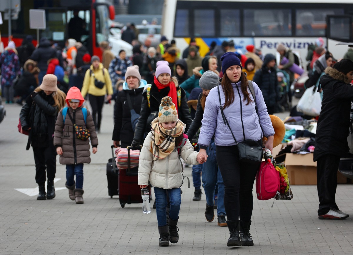 People arrive to a temporary accommodation and transport hub for refugees, after fleeing the Russian invasion of Ukraine, in Przemysl, Poland, March 8, 2022. REUTERS/Fabrizio Bensch
