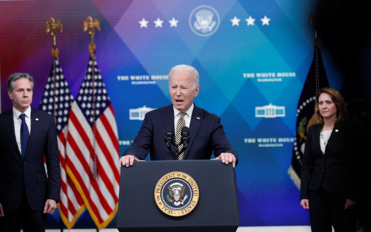 U.S. President Joe Biden is flanked by Secretary of State Antony Blinken and Deputy Secretary of Defense Kathleen Hicks as he speaks about assistance the U.S. government is providing to Ukraine amid Russia's invasion of the neighboring country, before signing an executive order on the aide in the Eisenhower Office Building's South Court Auditorium at the White House in Washington, U.S., March 16, 2022. REUTERS/Tom Brenner
