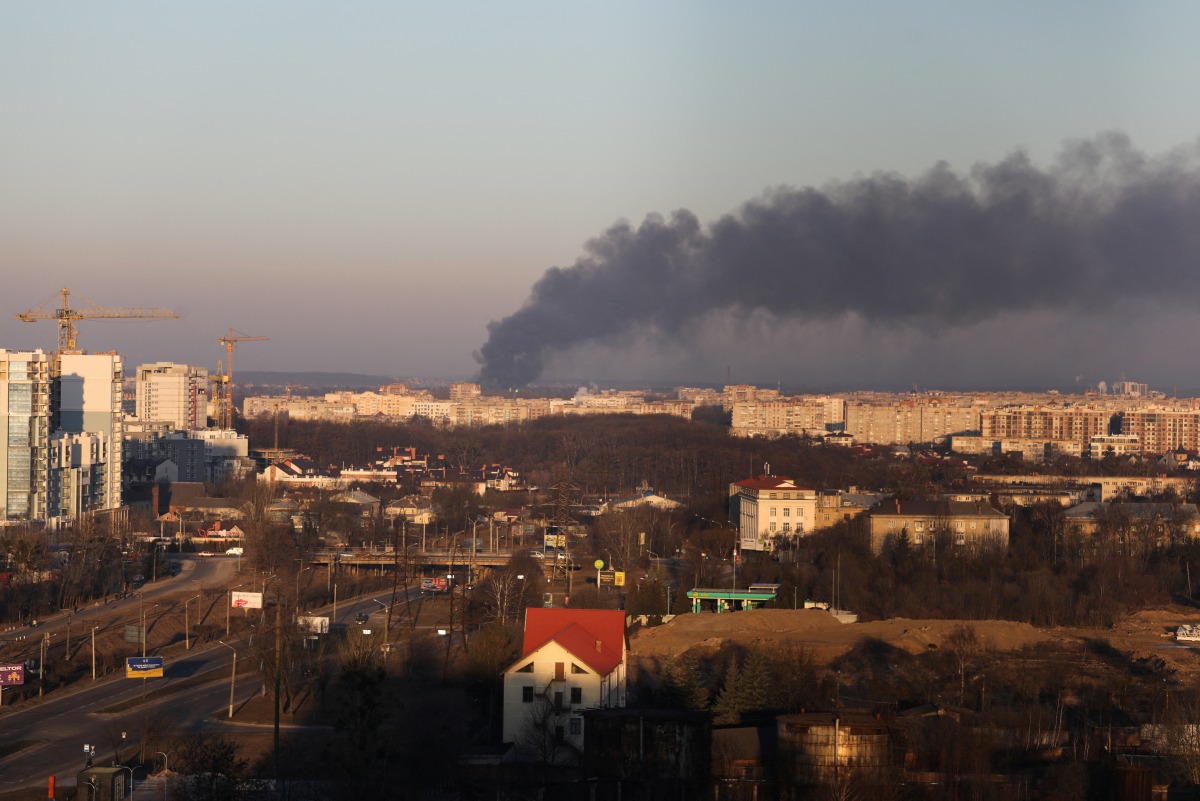 Smoke rises above buildings near Lviv airport, as Russia's invasion of Ukraine continues, in Lviv, Ukraine, March 18, 2022. REUTERS/Roman Baluk
