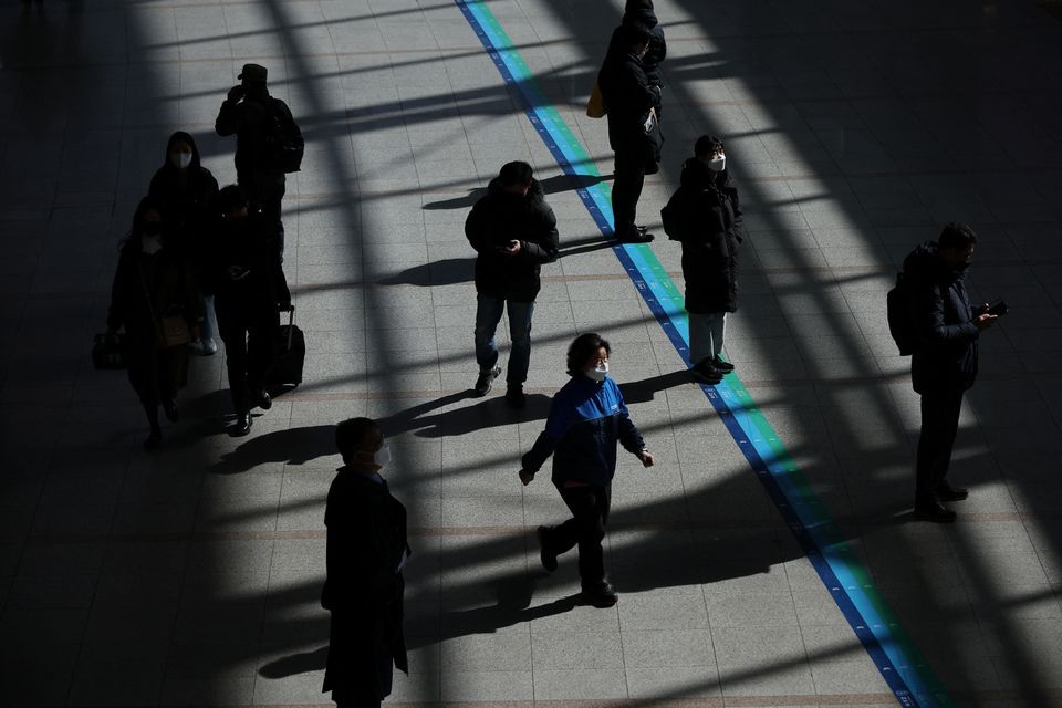 People wearing masks to prevent contracting the coronavirus disease (COVID-19) walk at a railway station in Seoul. Reuters photo