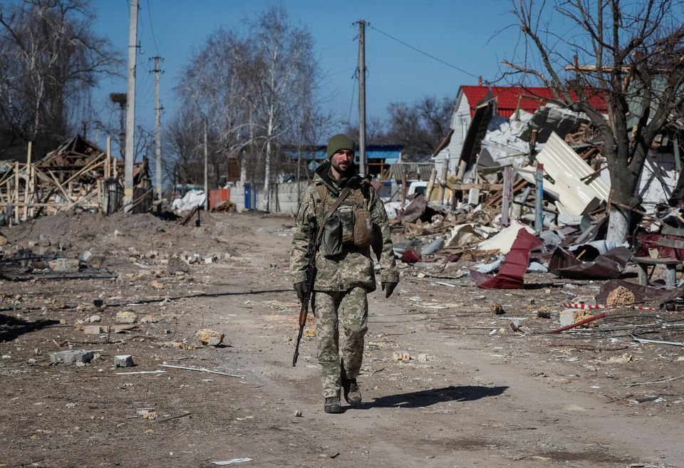 A Ukrainian service member walks, as the Russian invasion continues, in a destroyed village on the front line in the east Kyiv region, Ukraine March 21, 2022. REUTERS/Gleb Garanich


