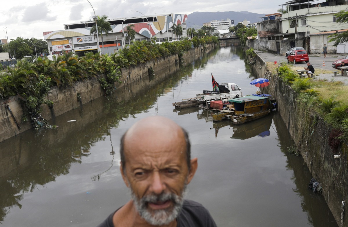 Luiz Bispo, who is living at Pavuna River which flows to Guanabara Bay, stands near his floating house what he says is an artistic installation developed by him to bring joy to the region and awareness to pollution of its waters, in Rio de Janeiro, Brazil March 21, 2022. Picture taken March 21, 2022. REUTERS/Ricardo Moraes
