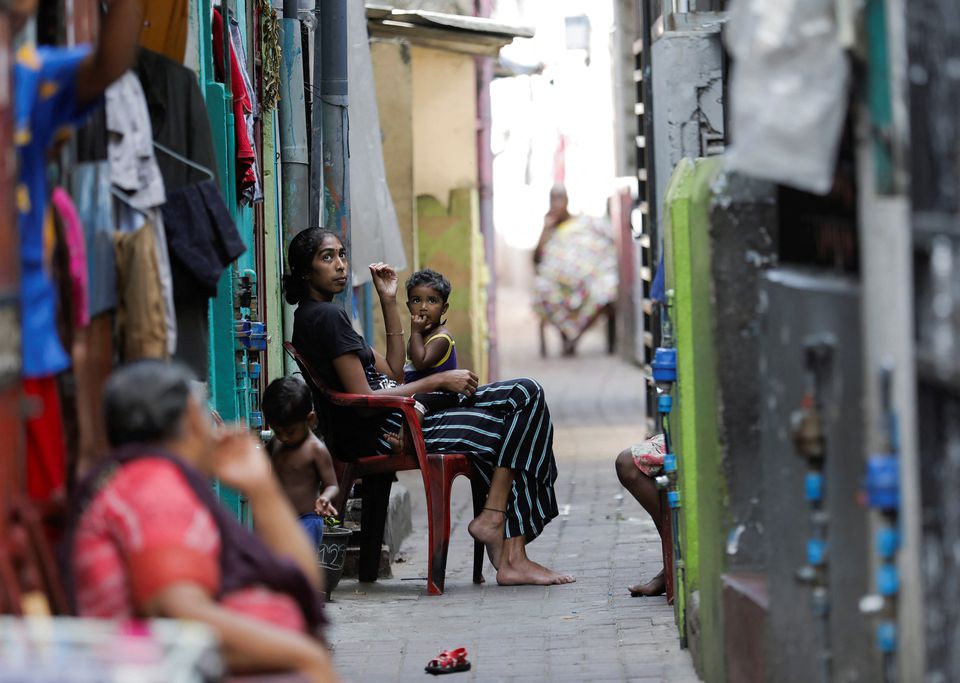 People sit outside to cool themselves from heat during the power cut as many parts of the country currently face long power cuts, as currency shortage makes fuel scarce, in Colombo, Sri Lanka March 31, 2022. REUTERS/Dinuka Liyanawatte


