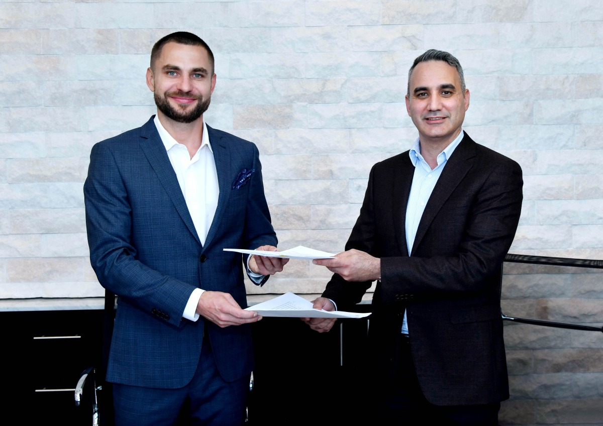 Mycrane founder and CEO Andrei Geikalo (left) signs a franchise agreement for Qatar with Kamal Kassab , managing director and founder of Ant Dynamics.