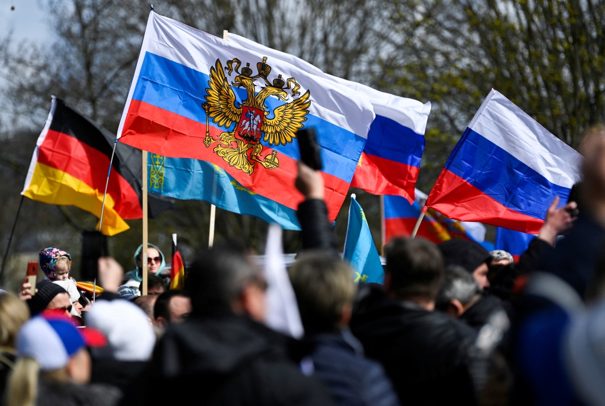 People hold Russian flags as pro-Russia supporters gather to take part in a motorcade in Hanover, Germany, April 10, 2022. REUTERS/Fabian Bimmer
