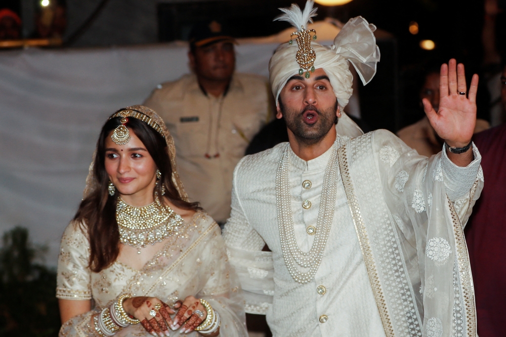 Bollywood actors Alia Bhatt and Ranbir Kapoor greet the media during a photo-op after their wedding function in Mumbai, India, April 14, 2022. REUTERS/Francis Mascarenhas