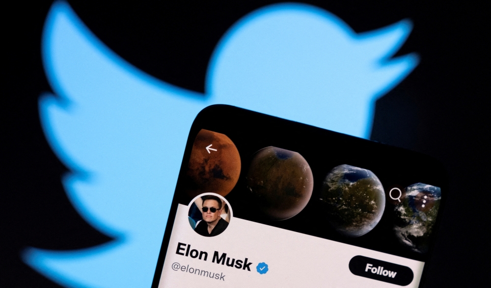 Elon Musk's Twitter account is seen on a smartphone in front of the Twitter logo in this photo illustration taken, April 15, 2022. Reuters/Dado Ruvic/Illustration/File Photo