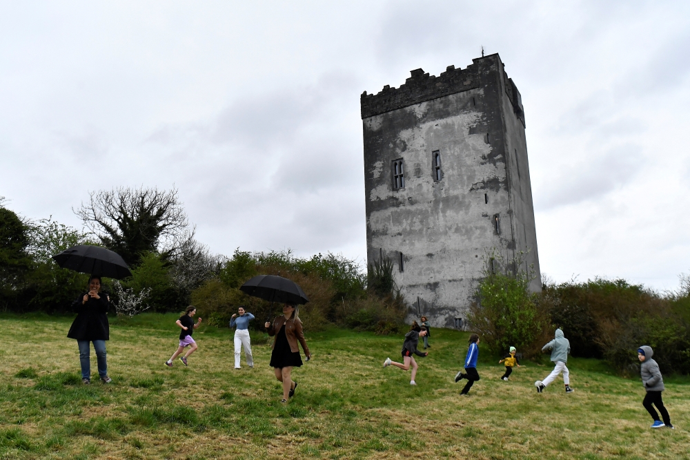 Ukrainian refugee children from Dnipro and Zaporizhzhia play football on the grounds of15th Century Ballindooley Castle in Galway, Ireland, April 16, 2022. Owner Barry Haughian has offered his castle as shelter for two families of Ukrainian refugees to stay in. Picture taken April 16, 2022. REUTERS/Clodagh Kilcoyne