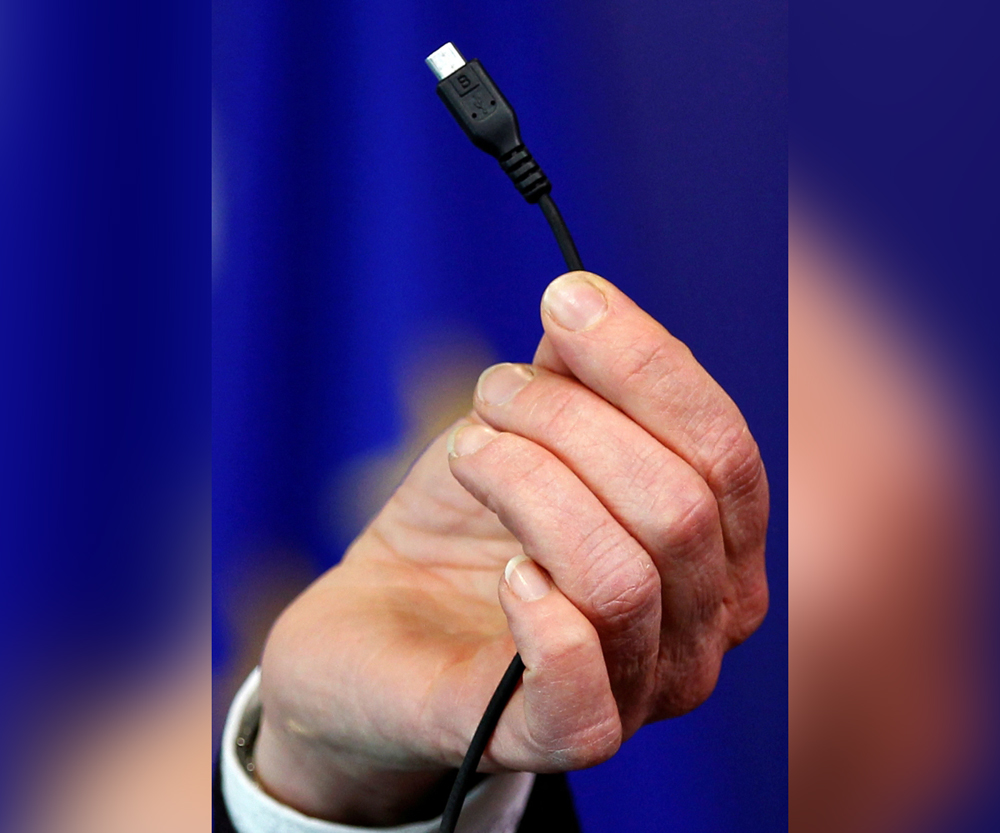 Bridget Cosgrave, Director General of DigitalEurope, displays a harmonised mobile phone charger during a news conference at the European Commission headquarters in Brussels February 8, 2011. REUTERS/Francois Lenoir/File Photo