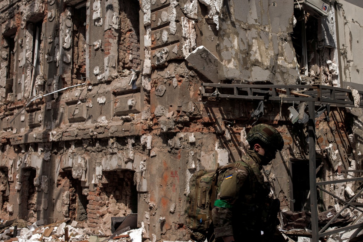 FILE PHOTO: A Ukrainian soldier walks next to a destroyed building following Russian shelling, as Russia's attack on Ukraine continues, in Kharkiv, Ukraine, April 16, 2022. REUTERS/Alkis Konstantinidis/File Photo
