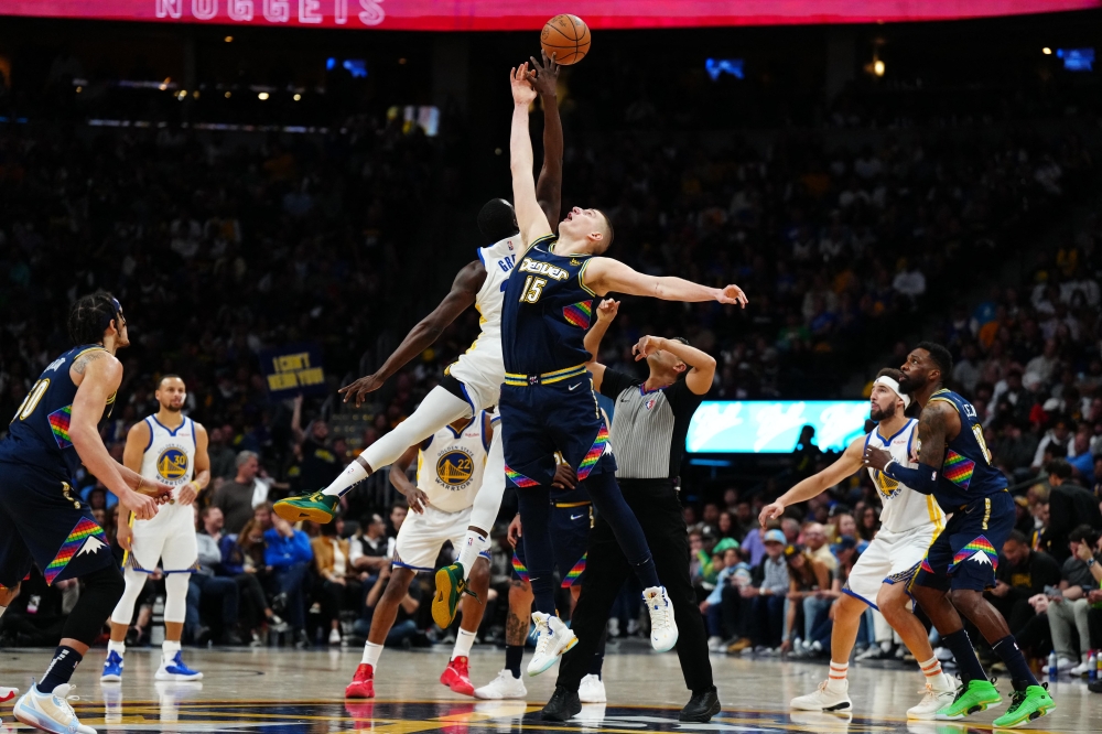 Denver Nuggets center Nikola Jokic (15) and Golden State Warriors forward Draymond Green (23) reach for a jump ball in the second half of the first round for the 2022 NBA playoffs at Ball Arena.  Ron Chenoy