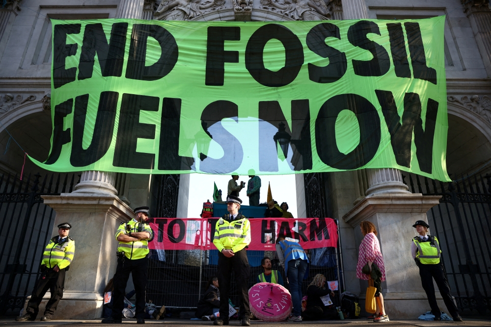 Activists from the Extinction Rebellion drape a banner across Marble Arch as part of a protest in central London, Britain, April 16, 2022. REUTERS/Henry Nicholls/File Photo