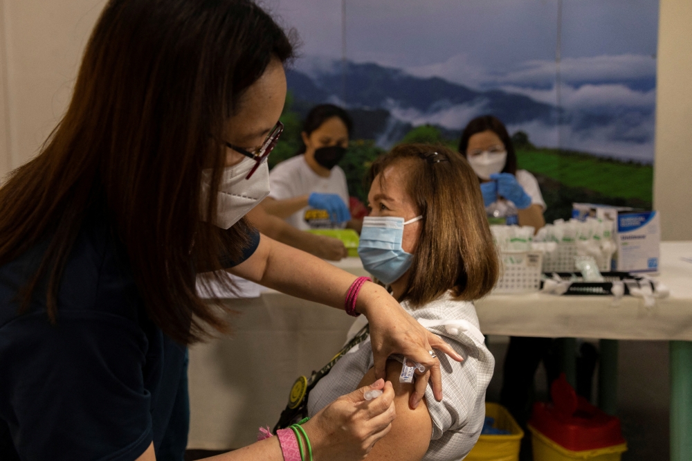 A hospital worker is inoculated with a booster dose of Pfizer-BioNTech COVID-19 vaccine against the coronavirus in Valenzuela Medical Center, Valenzuela City, Philippines, April 25, 2022. REUTERS/Eloisa Lopez