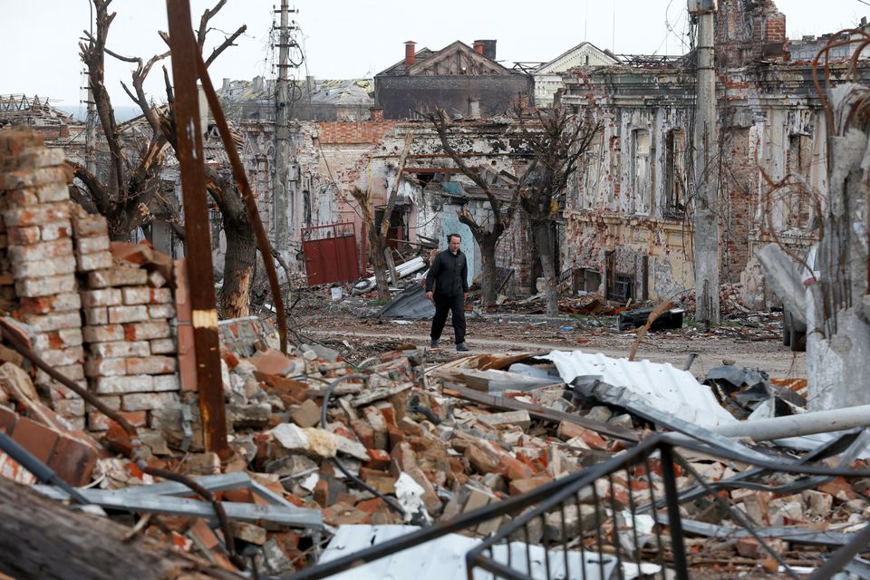 A man walks near damaged buildings in the course of Ukraine-Russia conflict in the southern port city of Mariupol, Ukraine April 22, 2022. REUTERS/Alexander Ermochenko


