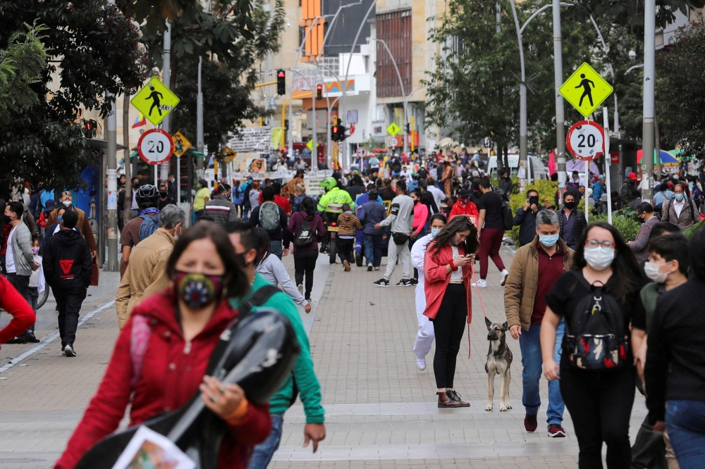 People wearing face masks walk down a street before the start of a mandatory total isolation decreed by the mayor's office, amidst an outbreak of the coronavirus disease (COVID-19), in Bogota, Colombia January 7, 2021. REUTERS/Luisa Gonzalez/File Photo/File Photo