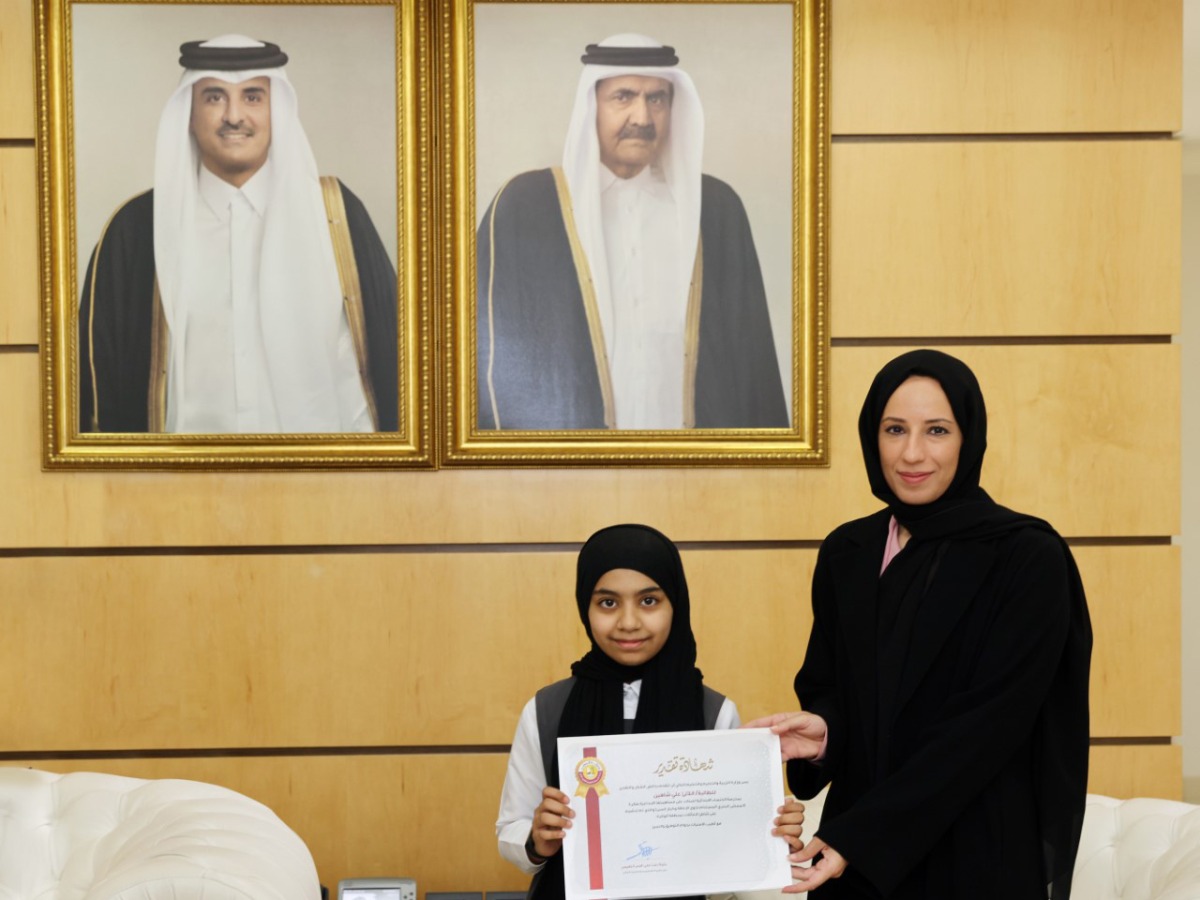 Minister of Education and Higher Education H E Buthaina bint Ali Al Jabr Al Nuaimi honouring a student for her research work.