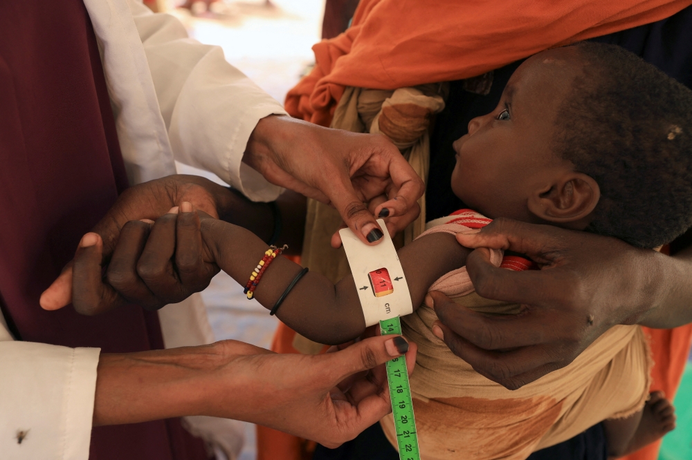 A health worker takes a measurement of 8-month-old Abdurahman Bishar, at a clinic for malnourished children, at the Higlo camp for people displaced by drought, in the town of Gode, Somali Region, Ethiopia, April 26, 2022. Pictures taken April 26, 2022. REUTERS/Tiksa Negeri