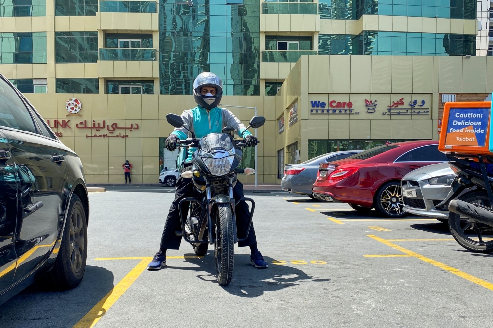 A food delivery worker rides a motorbike to deliver meal orders, following the outbreak of the coronavirus disease (COVID-19), in Dubai, United Arab Emirates, May 14, 2020. Reuters/Abdel Hadi Ramahi/File Photo