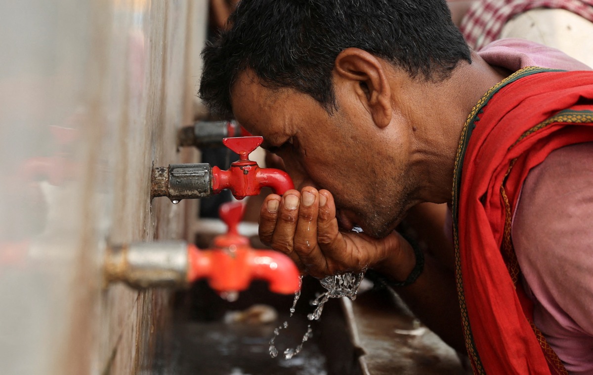 FILE PHOTO: A labourer drinks water from a public drinking water tap on a hot summer day in the old quarters of Delhi, India, May 4, 2022. REUTERS/Anushree Fadnavis/File Photo
