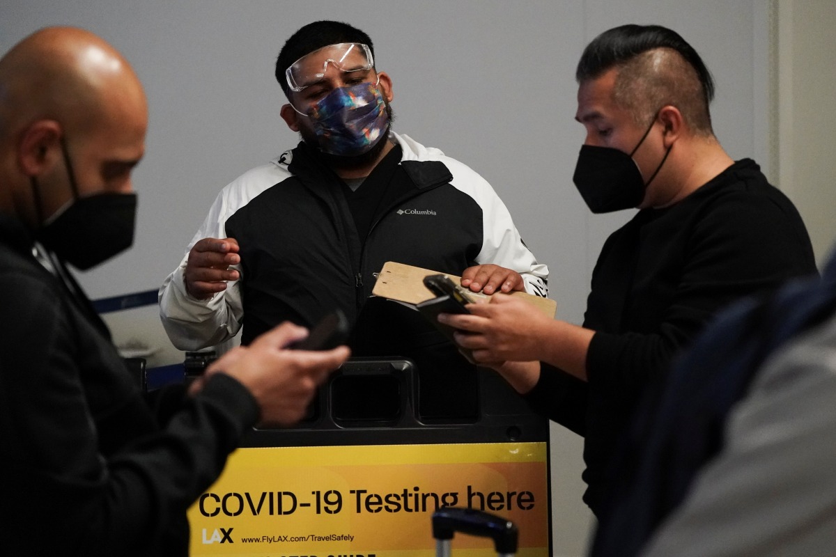 Travelers wait in line to get tests for the coronavirus disease (COVID-19) at a pop-up clinic at Tom Bradley International Terminal at Los Angeles International Airport, California, U.S., December 22, 2021. REUTERS/Bing Guan

