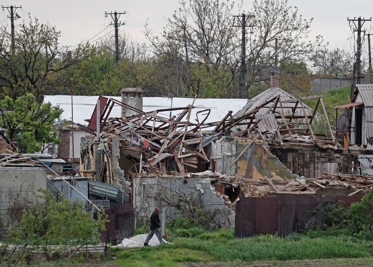 A local resident walks past houses destroyed during Ukraine-Russia conflict in the southern port city of Mariupol, Ukraine May 5, 2022. Picture taken May 5, 2022. REUTERS/Alexander Ermochenko
