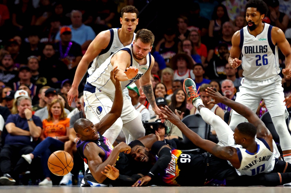 Phoenix Suns forward Jae Crowder (99) and center Bismack Biyombo (18) go for the ball against Dallas Mavericks guard Luka Doncic (77) and forward Dorian Finney-Smith (10) during the second quarter in game seven of the second round for the 2022 NBA playoffs at Footprint Center. Mark J. Rebilas-USA TODAY Sports