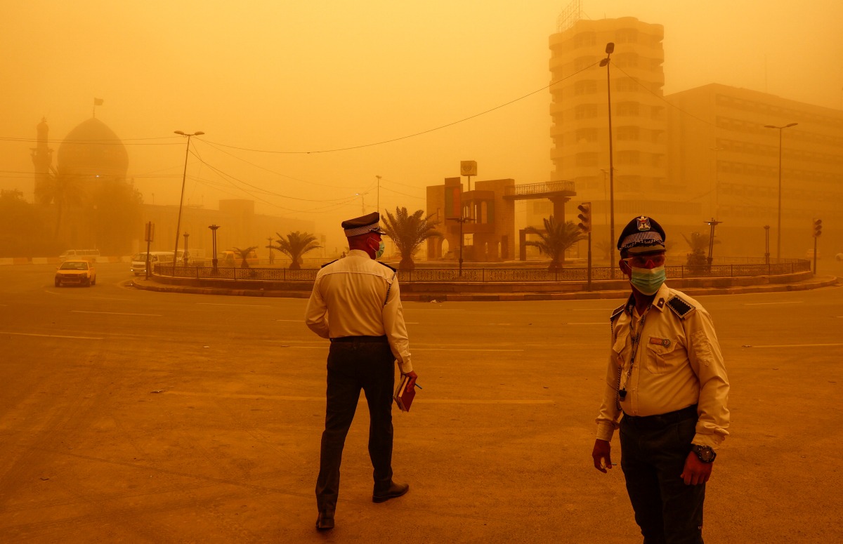 Traffic police officers direct vehicles during a sandstorm in Baghdad, Iraq, May 23, 2022. REUTERS/Thaier Al-Sudani
