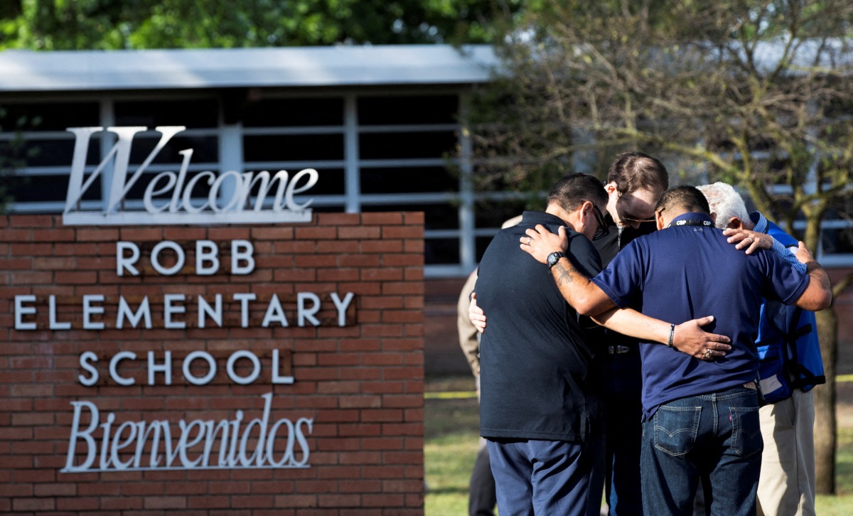 People gather at Robb Elementary School, the scene of a mass shooting in Uvalde, Texas, U.S., May 25, 2022. REUTERS/Nuri Vallbona 