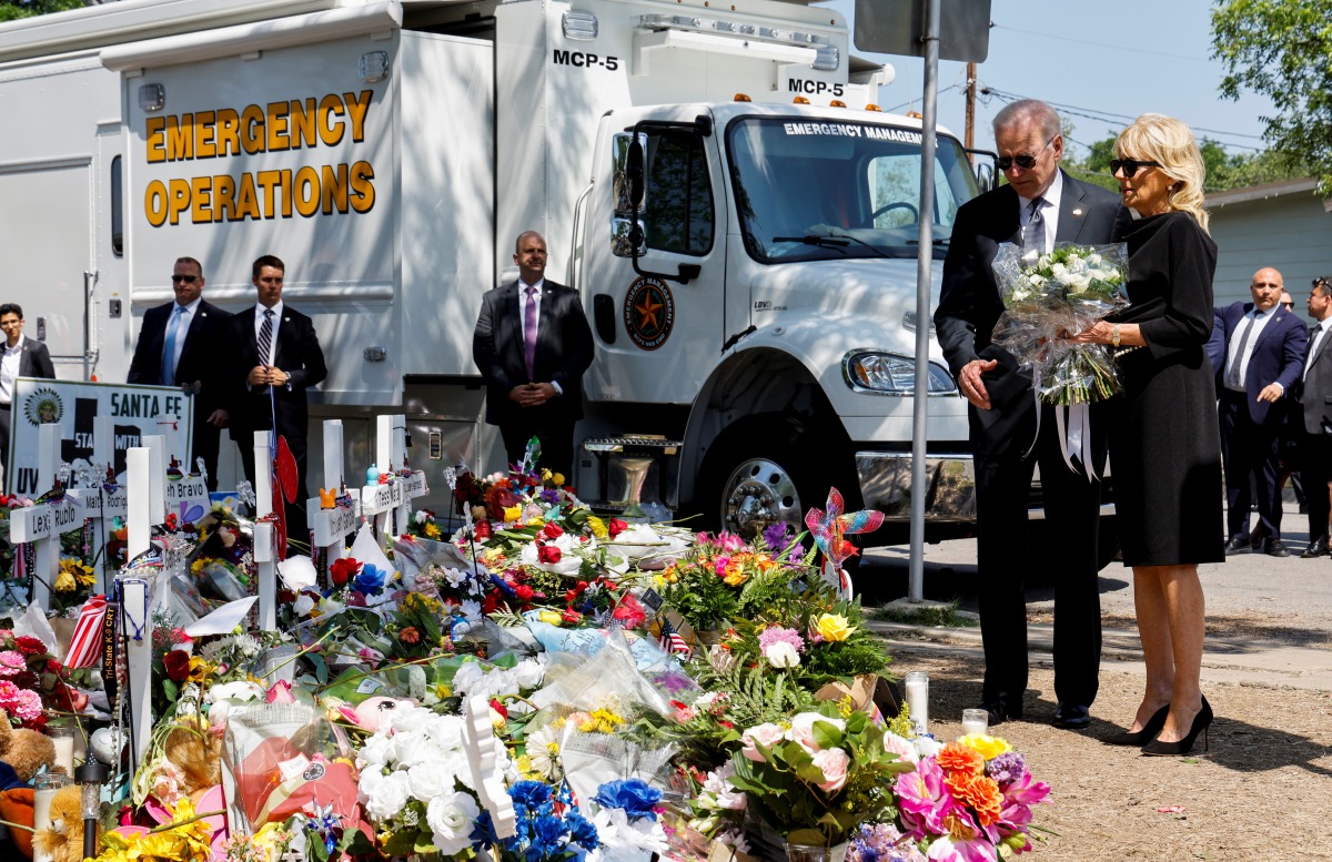 U.S. President Joe Biden and first lady Jill Biden, who holds a bouquet of 21 white flowers, pay their respects at the Robb Elementary School memorial, where a gunman killed 19 children and two teachers in the deadliest U.S. school shooting in nearly a decade, in Uvalde, Texas, U.S. May 29, 2022. REUTERS/Jonathan Ernst
