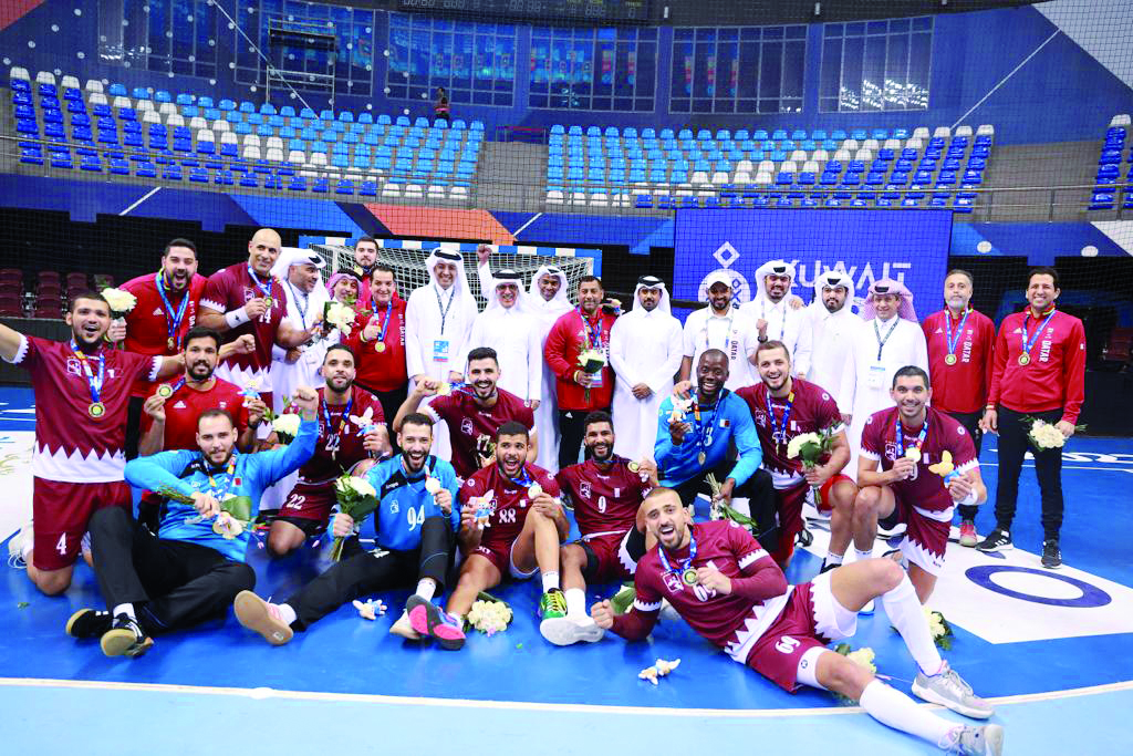 Qatar handball team players and officials celebrate with their medals.