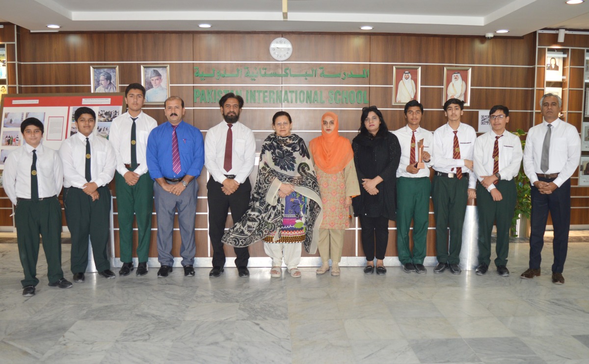 Principal of Pakistan International School Qatar (PISQ), Nargis Raza Otho, with debaters and their coach during a felicitation ceremony.