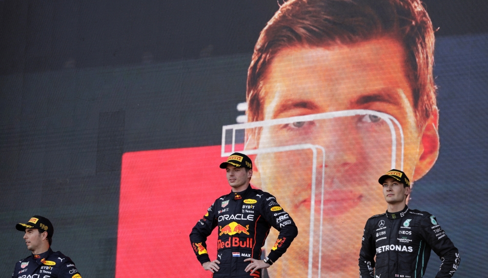 Red Bull's Max Verstappen celebrates on the podium after winning the race alongside second place Red Bull's Sergio Perez and third place Mercedes' George Russell REUTERS/Leonhard Foeger