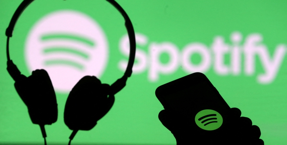 FILE PHOTO: A smartphone and a headset are seen in front of a screen projection of Spotify logo, in this picture illustration taken April 1, 2018. REUTERS/Dado Ruvic/Illustration/File Photo
