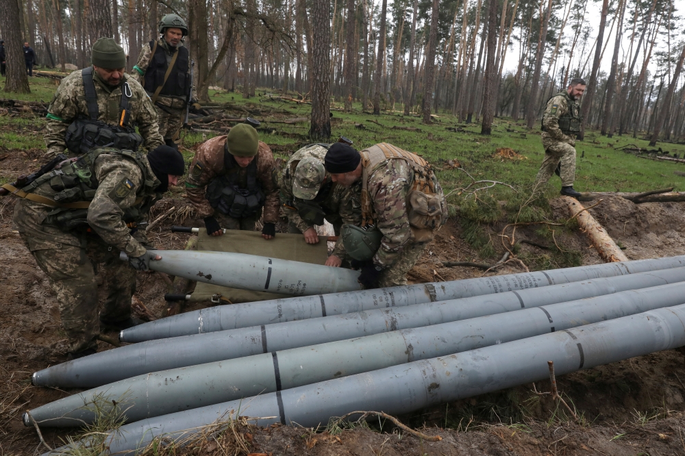 Military sappers place a combat part of a Russian Uragan multiple rocket launch shell left after Russia's invasion in Kyiv Region, Ukraine, recently. (Reuters/Mykola Tymchenko)