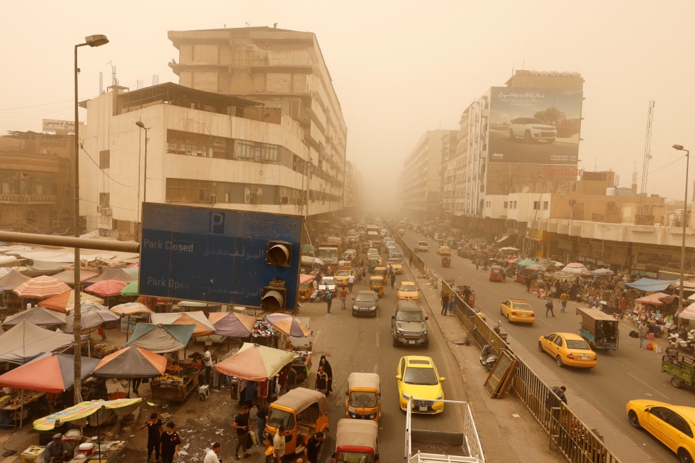 Cars drivers and residents gather at the Shorja wholesale market during a sandstorm in Baghdad, Iraq, July 3, 2022. (Reuters/Ahmed Saad)