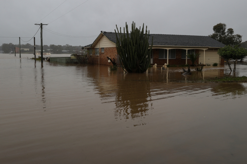 A home is inundated by floodwaters, following heavy rains and severe flooding in the McGraths Hill suburb of Sydney, Australia, July 6, 2022. REUTERS/Loren Elliott