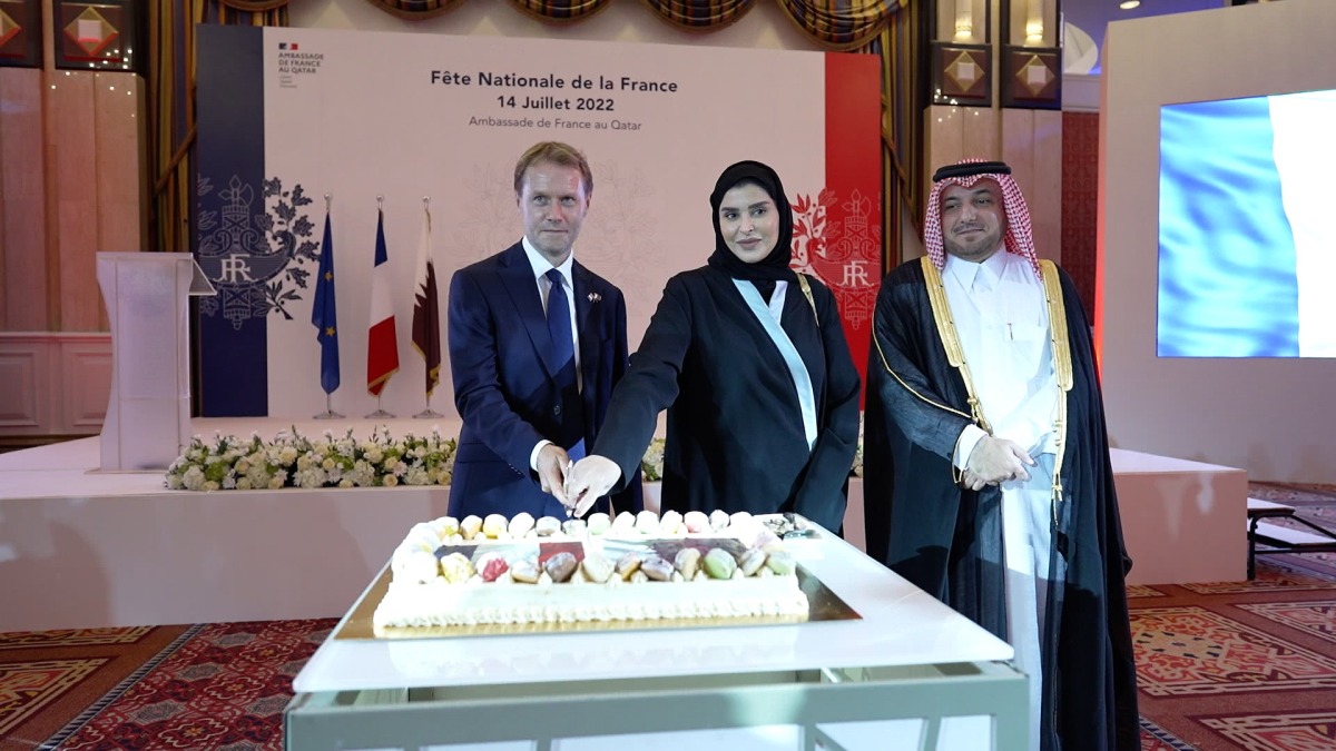 Minister of Social Development and the Family H E Mariam bint Ali bin Nasser Al Misnad and French Ambassador to Qatar H E Jean-Baptiste Faivre cutting the ceremonial cake, while  Director of Protocol at the Ministry of Foreign Affairs H E Ambassador Ibrahim Yousif Fakhroo looks on.