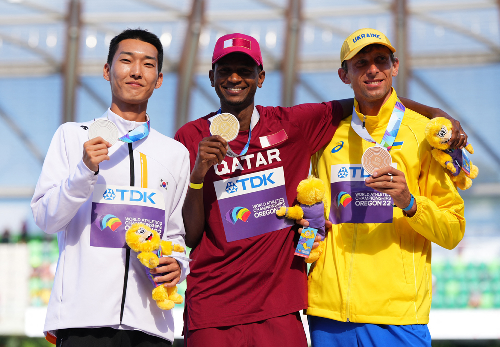 Gold Medallist Qatar’s Mutaz Essa Barshim celebrates on the podium alongside silver medallist Woo Sanghyeok  of South Korea and bronze medallist Andriy Protsenko of Ukraine during the medal ceremony.