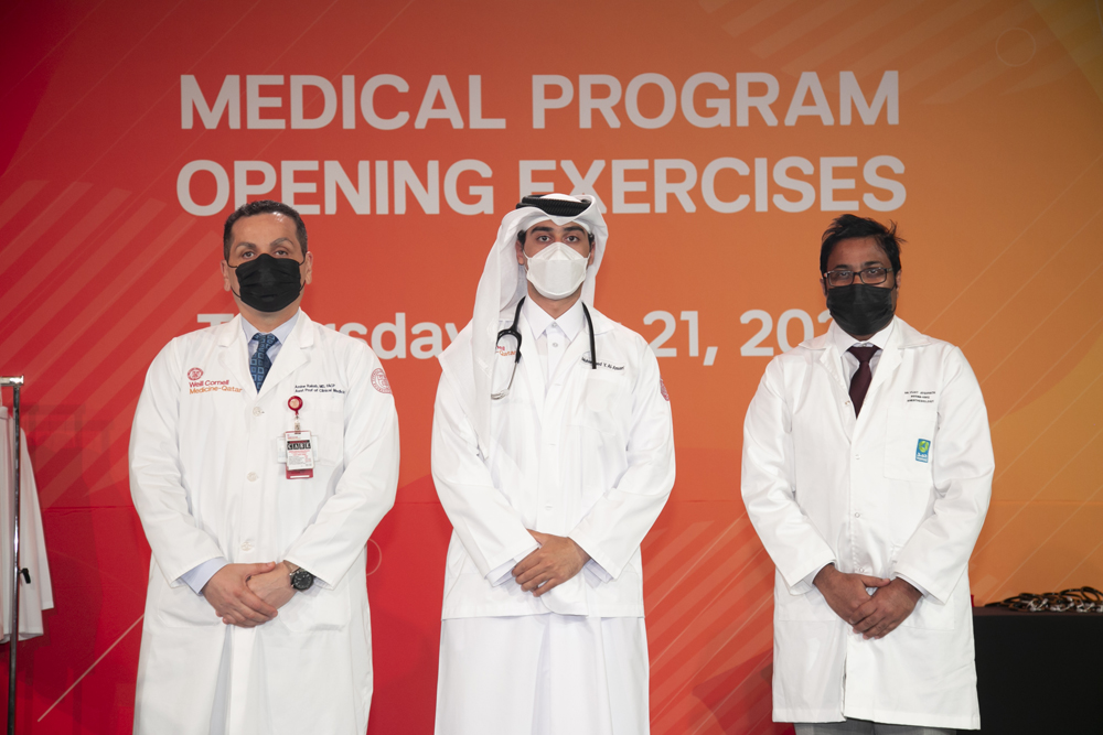 New WCM-Q first-year medical student Mohammed Al Ansari receives his white coat from Dr. Amine Rakab of WCM-Q (left) and Dr. Vijay Jeganath of HMC. 