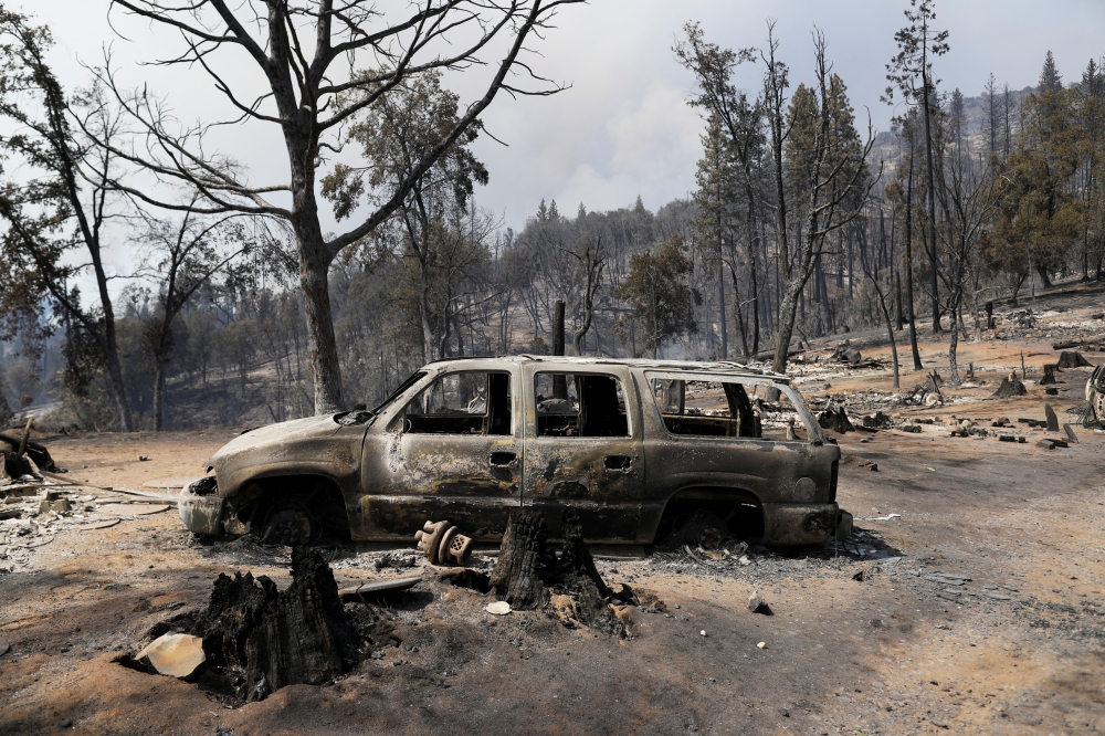 A car is seen burned as the Oak Fire burns near Jerseydale in Mariposa County, California, U.S. July 25, 2022. REUTERS/David Swanson